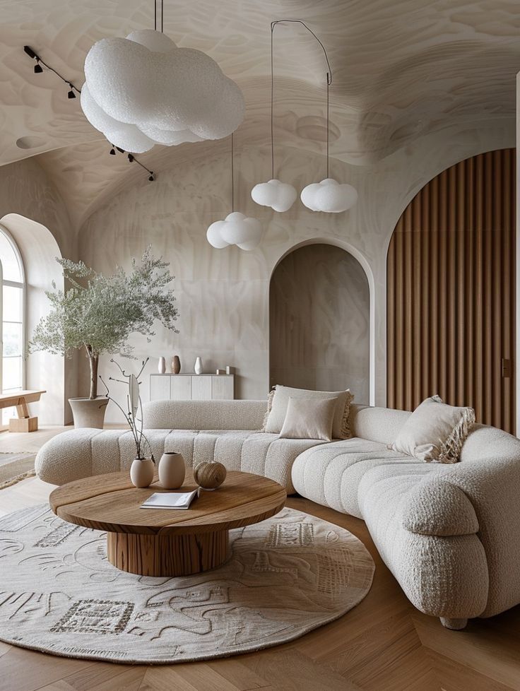Cozy living room with cloud lights, plush sofa, wooden coffee table, and archway, creating a warm, modern interior design.