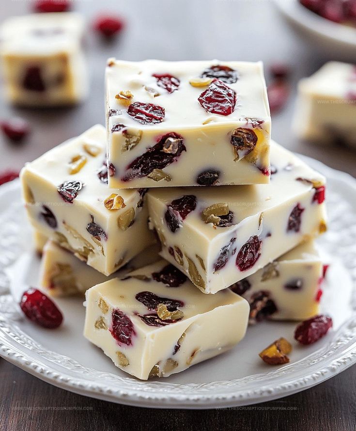 Delicious white chocolate fudge with cranberries and nuts on a plate, perfect for holiday treats and festive desserts.