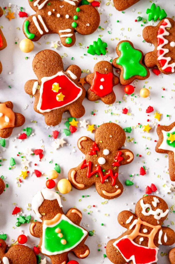 Colorful gingerbread cookies adorned with festive icing and candy decorations on a white background. Perfect for holiday celebrations.