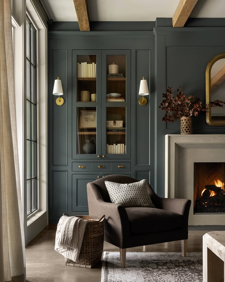 Cozy living room with a dark armchair, fireplace, and elegant built-in shelves, perfect for relaxation and reading by the fire.