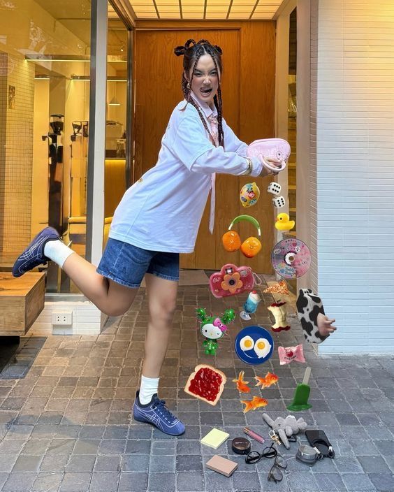 Young woman playfully poses with floating colorful toys and accessories, showcasing a vibrant street fashion style.