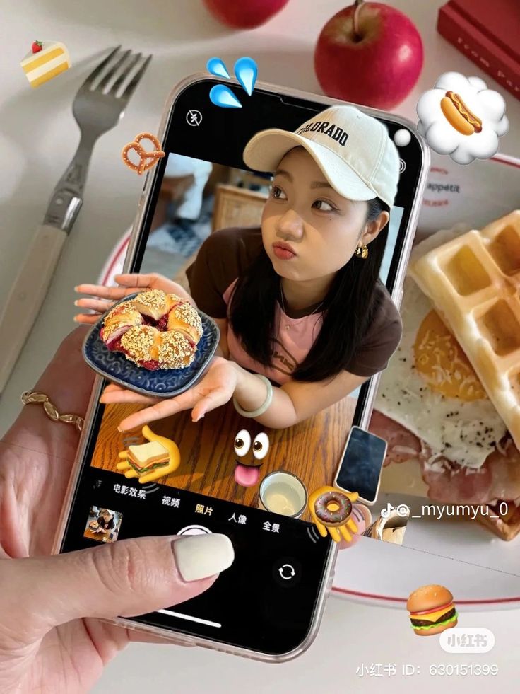 Creative phone display with a girl posing with fruit pastry. Surrounded by whimsical food emojis against a breakfast scene.
