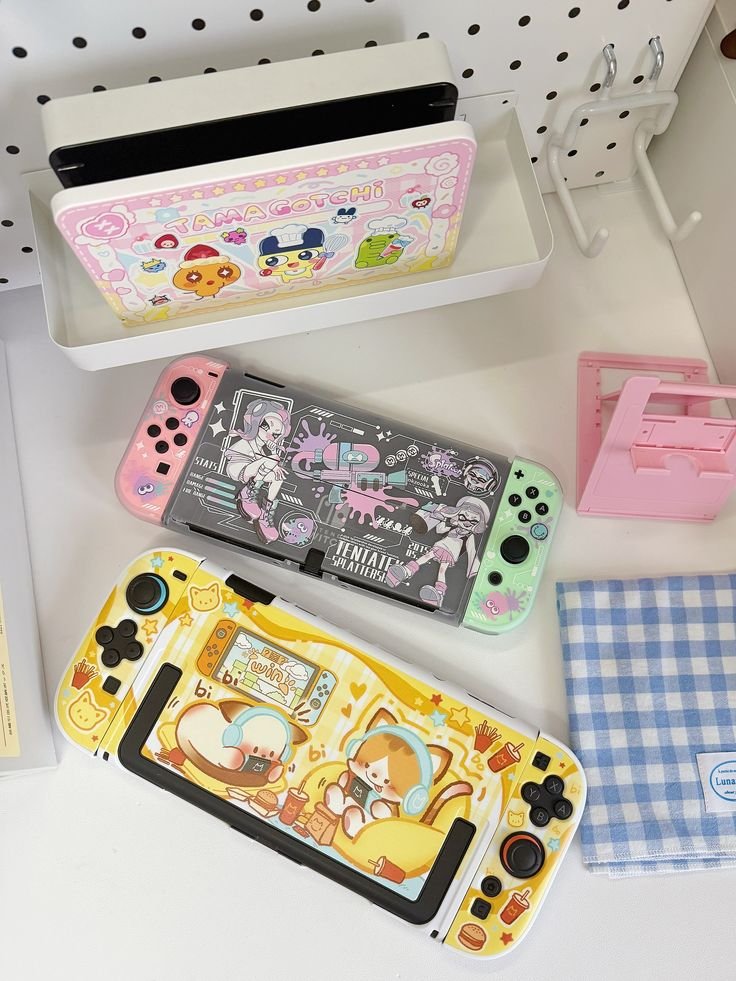 Customized gaming consoles with vibrant cartoon designs on a white desk, showcasing playful and colorful themes.
