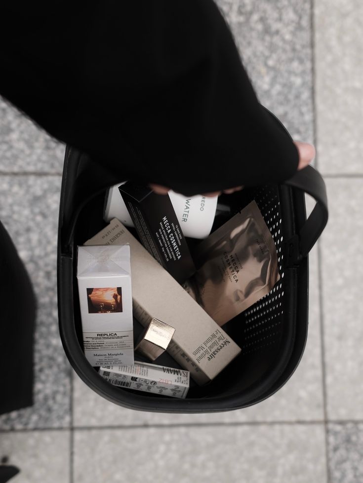Shopping basket filled with luxury cosmetics and skincare products on a tiled floor.