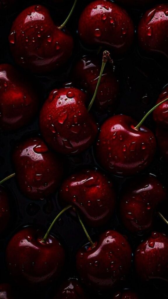 Close-up of fresh red cherries with water droplets, showcasing juicy and ripe summer fruit.
