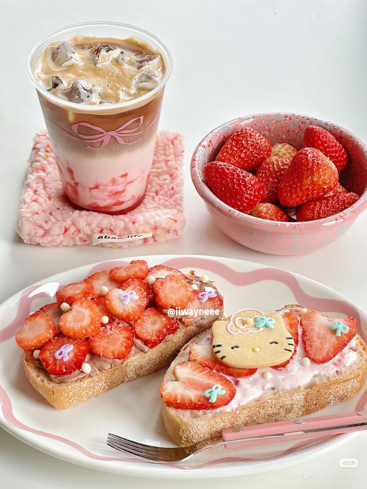 Delicious strawberry-themed breakfast with iced latte, fresh berries, and cute decorated toast. Perfect for a sweet morning treat.