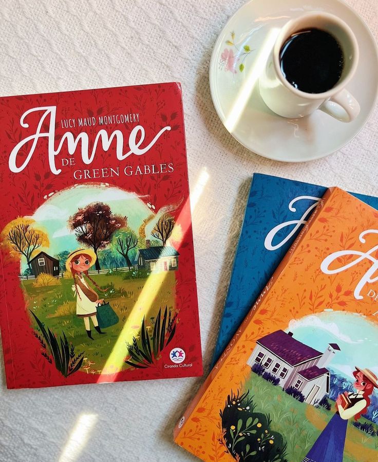 Anne of Green Gables books with a cup of coffee on a table; colorful covers feature illustrated Anne and scenic backdrop.