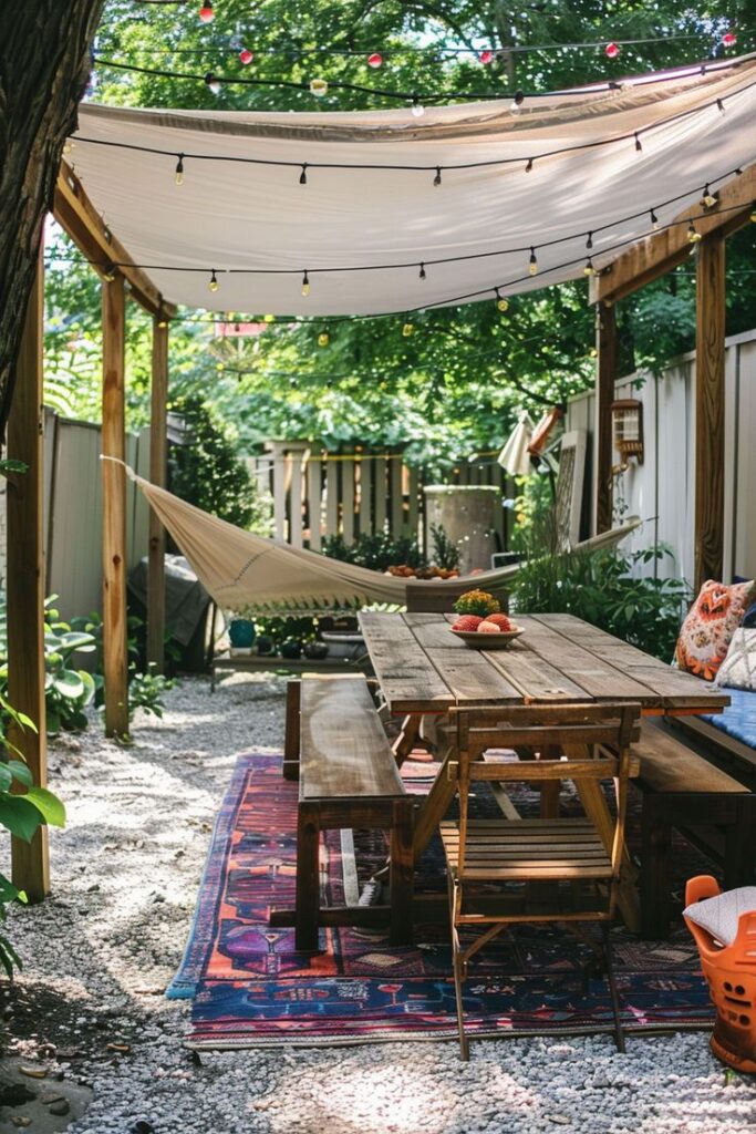 Cozy outdoor patio with wooden table, hammock, and string lights under a shaded canopy. Perfect for relaxing and entertaining.