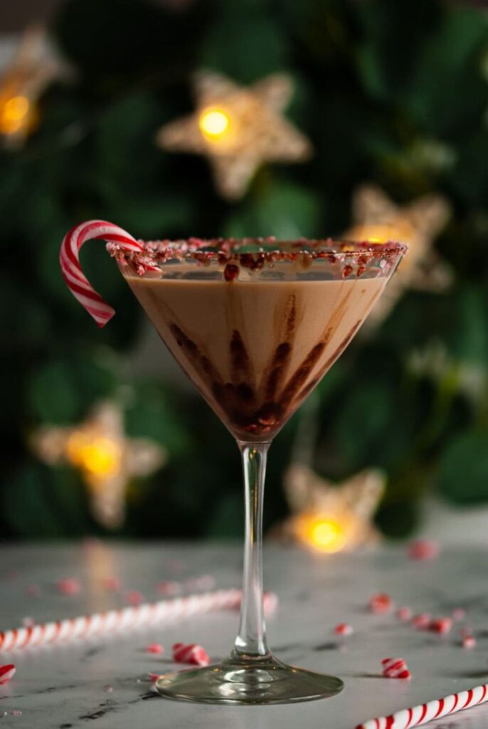 Festive chocolate martini with a candy cane garnish and sprinkles, perfect for holiday celebrations.