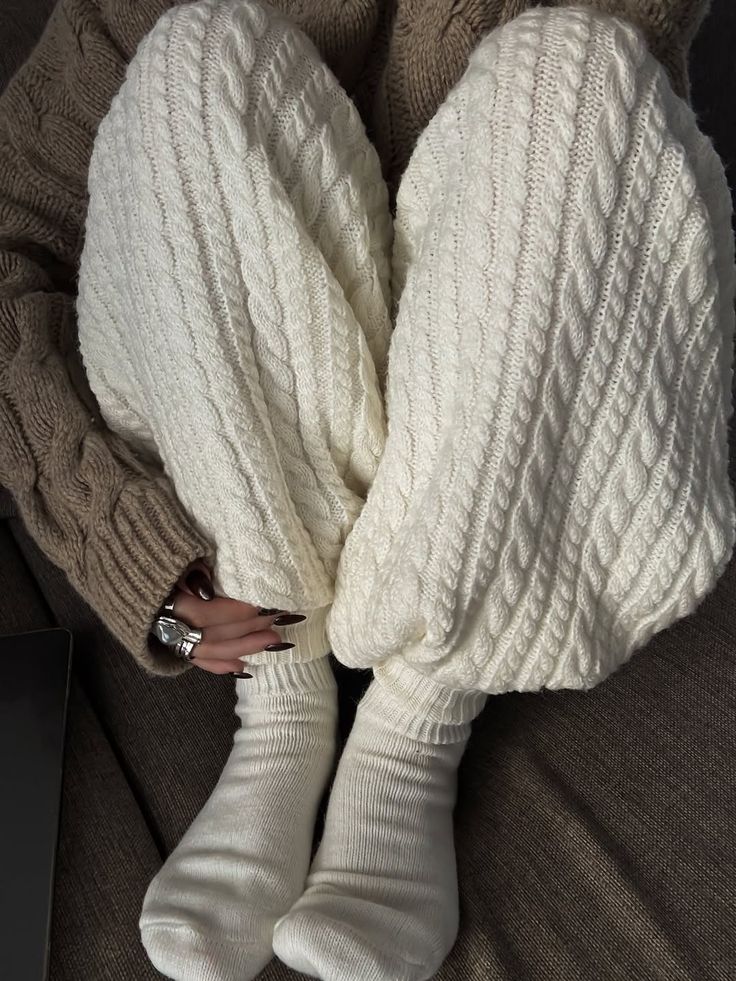 Cozy winter style with cable knit pants, thick socks, and a chunky sweater, perfect for lounging on a chilly day.