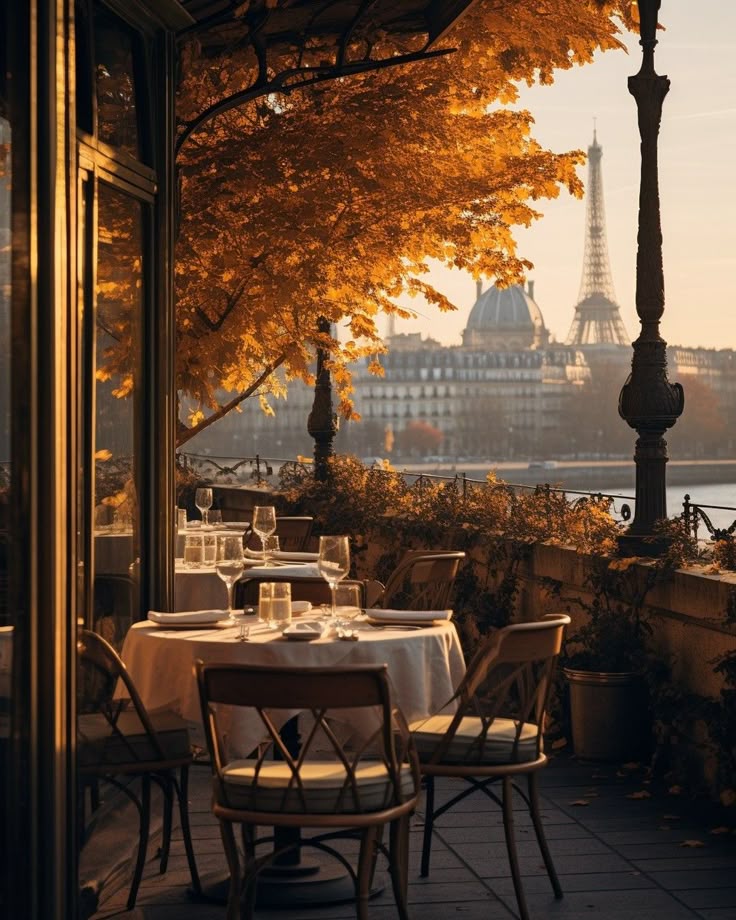 Outdoor Parisian cafe with fall leaves, Eiffel Tower view in background, elegantly set table for dining.