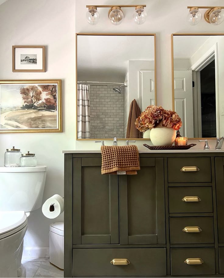 Modern bathroom with dual mirrors, stylish dark vanity, vase of hydrangeas, soft lighting, and cozy towels for an elegant look.