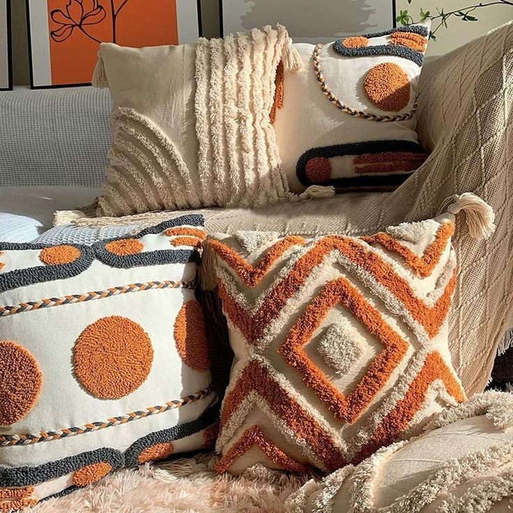 Cozy living room with decorative pillows featuring orange geometric patterns and textures, adding warmth and style to the space.