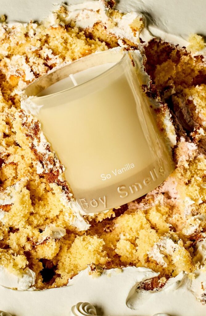 Vanilla scented candle nestled in crumbled cake, enhancing cozy ambiance and sweet aromas. Perfect for home fragrance lovers.
