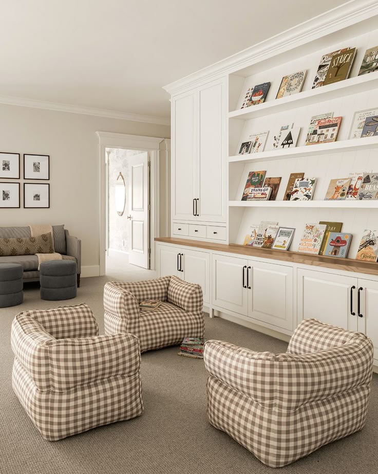 Cozy reading room with plaid chairs, a built-in bookshelf, and children's books. Ideal for a comfortable and inviting atmosphere.