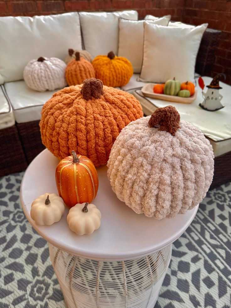 Cozy autumn decor with knitted pumpkins and small gourds on a patio, perfect for fall inspiration and seasonal home styling.