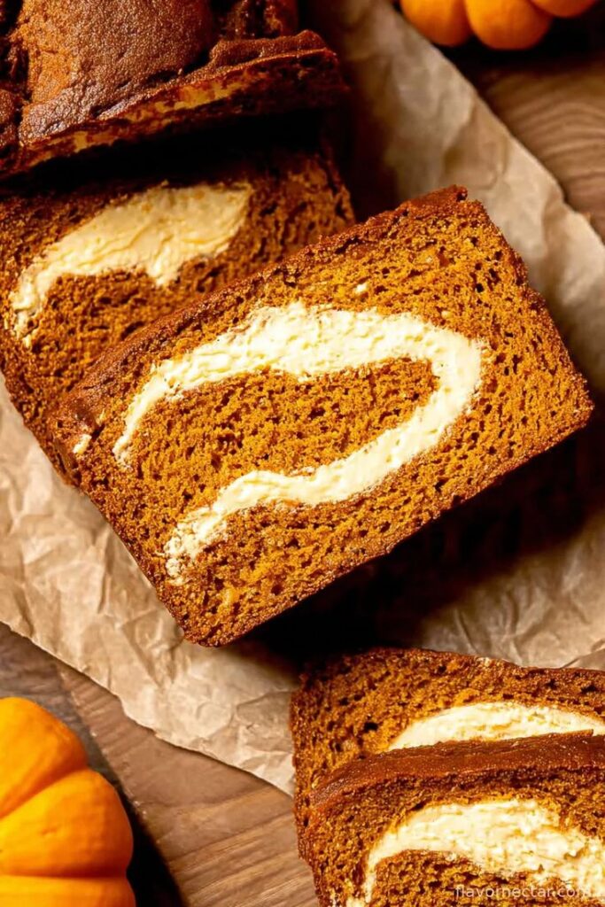Pumpkin bread with a creamy swirl, sliced and ready to enjoy. Perfect for fall treats and holiday gatherings.