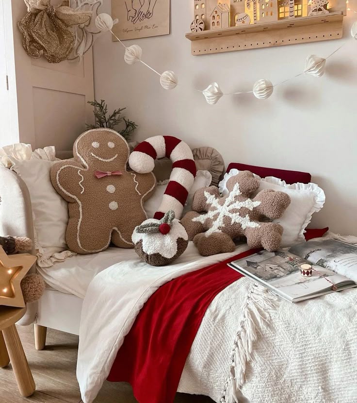 Cozy Christmas-themed bedroom with festive pillows including gingerbread, candy cane, and snowflake designs on a comfy bed.
