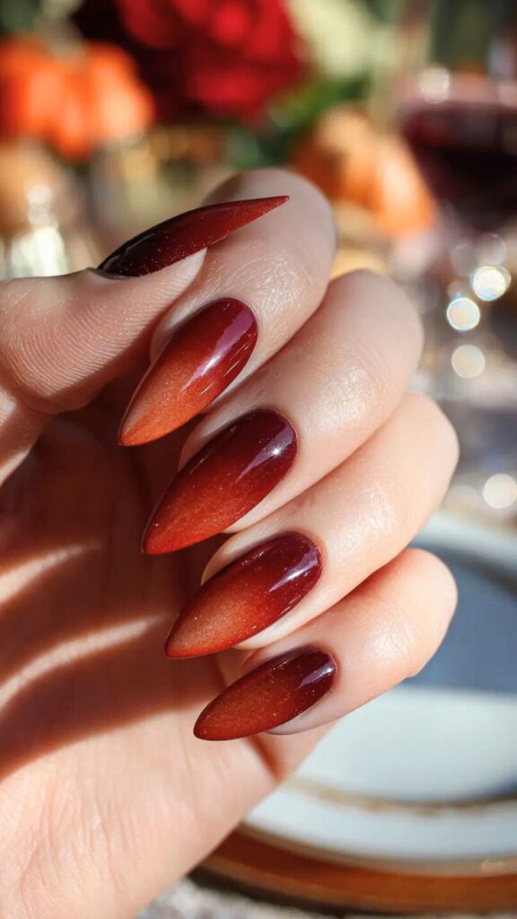 Stylish ombre red to orange stiletto nails, perfect for a trendy autumn manicure.