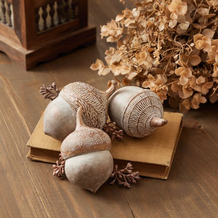 Decorative acorns and dried flowers on a rustic wooden table create a cozy autumn atmosphere.