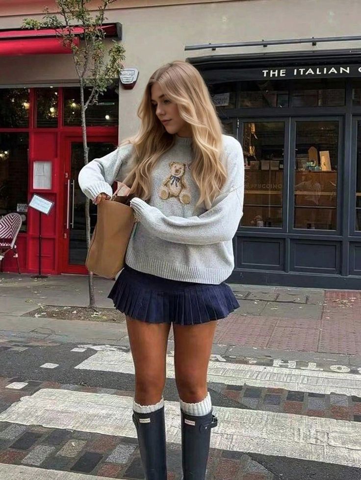 Woman in cozy teddy sweater and skirt stands at a crosswalk near an Italian café, looking into her bag.