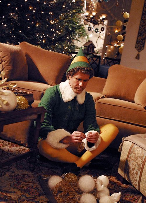 Man dressed as an elf decorating for Christmas in cozy living room with festive tree and lights. Holiday spirit and home adornment.