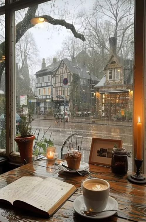Cozy café scene with a rainy street view, featuring a latte, open book, and candlelit ambiance. Perfect for relaxing moments.