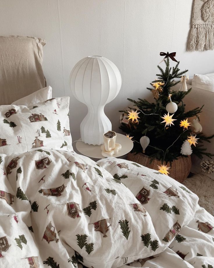 1374a069-22b5-4461-babc-d99b456963cc - Handy Home Cozy bedroom with festive bedding, a unique lamp, and a small decorated Christmas tree with star lights. Winter decor vibe.