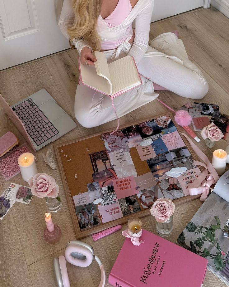 14ad5d72-fd74-43a4-a086-674547970b6b - Handy Home Person creating a vision board with pink-themed accessories, a notebook, laptop, and candles for inspiration and planning.