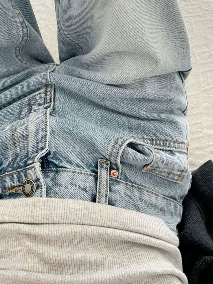 Close-up of light blue jeans with a gray ribbed shirt, showcasing casual fashion style and denim texture.