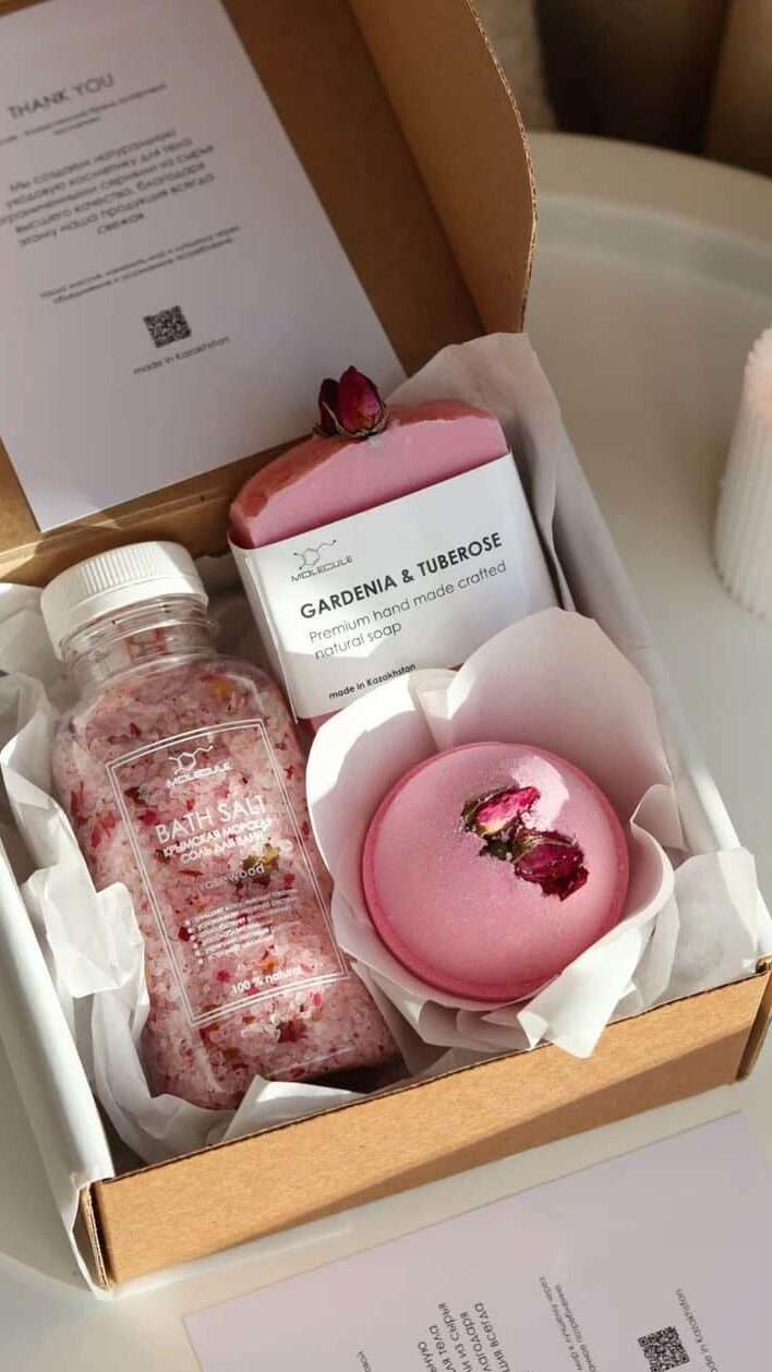 Gift set with bath salts, gardenia soap, and rose bath bomb in a box, perfect for a relaxing spa day.
