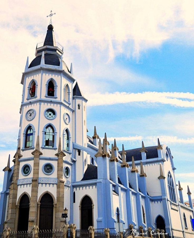 Church of Saint António Reguengos de Monsaraz - Handy Home Gothic-style church with blue sky, featuring arched windows, clock tower, and pointed spires.