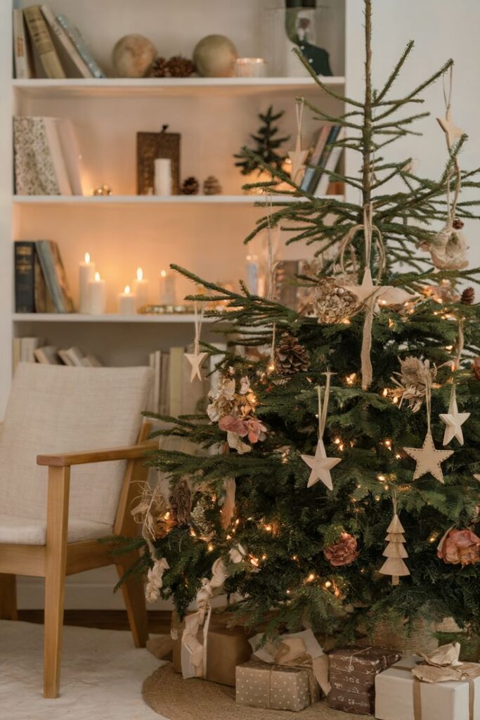 Eco-Friendly Christmas Tree Decoration Ideas 🌍💚 - Handy Home Cozy Christmas living room with decorated tree, twinkling lights, wrapped gifts, and candles on the shelf. Warm holiday ambiance.
