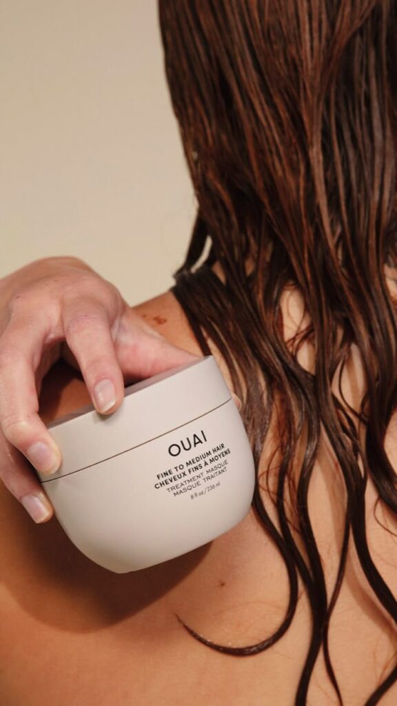 Fine To Medium Hair Treatment Masque - Handy Home Person applying Ouai hair treatment masque to wet hair for fine to medium texture care.
