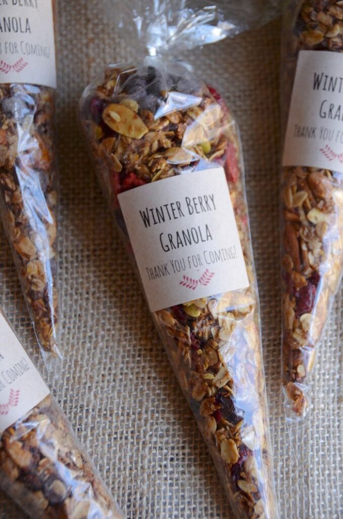 Homemade Winter Berry Granola - Handy Home Packaged winter berry granola in clear bags with thank you labels, displayed on burlap fabric for a rustic touch.
