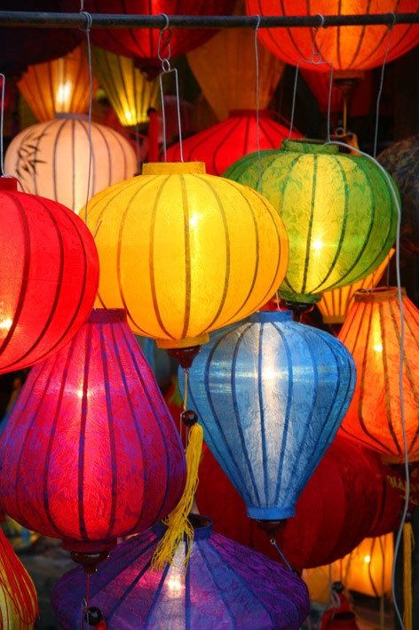 Memories of Vietnam - Handy Home Colorful hanging lanterns lit up at night, showcasing vibrant reds, blues, yellows, and greens for a festive atmosphere.