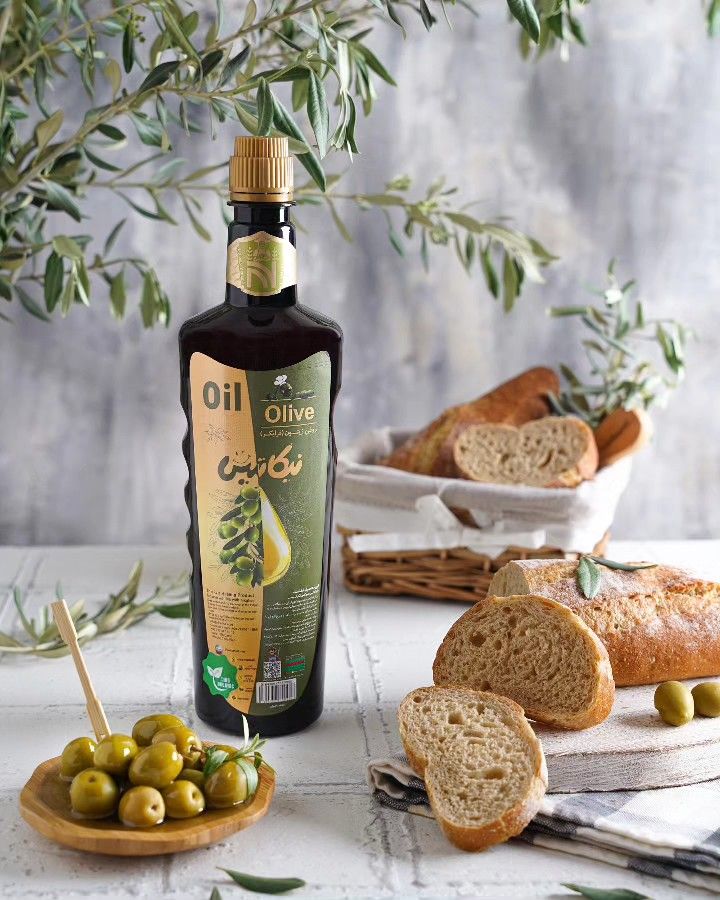 Bottle of olive oil with sliced bread and olives on a rustic table. Perfect for Mediterranean cuisine lovers.