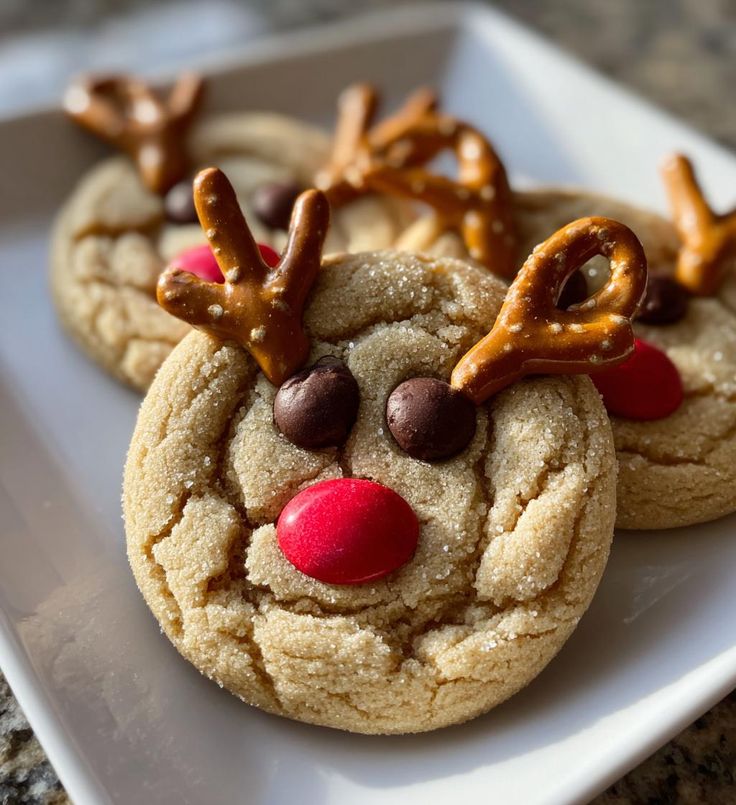 Peanut Butter Reindeer Cookies_ 5 Steps to Holiday Magic - Handy Home Festive reindeer cookies with pretzel antlers, chocolate eyes, and a red candy nose on a plate. Perfect for holiday treats!