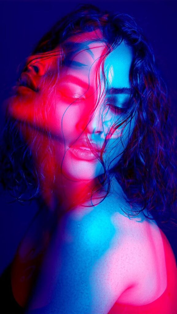 agbaE - Handy Home Artistic portrait of a woman with vibrant pink and blue lighting, creating a surreal and dreamy effect.