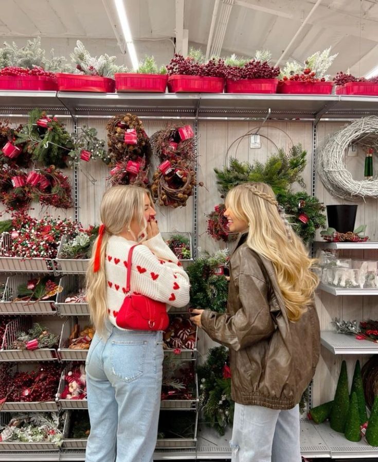 b57a6d48-cb67-4b7d-a0ab-33254105a205 - Handy Home Two women shopping for Christmas wreaths in a festive store, surrounded by holiday decorations.