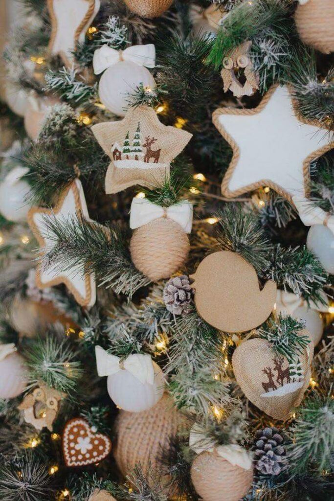 c4665198-77e2-4f80-b8c4-bf5dc92b49de - Handy Home Christmas tree adorned with rustic burlap and star ornaments, reindeer designs, and pinecones, creating a cozy holiday ambiance.