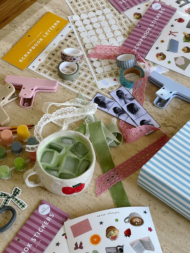 Creative scrapbooking supplies with stickers, ribbons, and a mug of iced matcha for an inspiring DIY craft session.