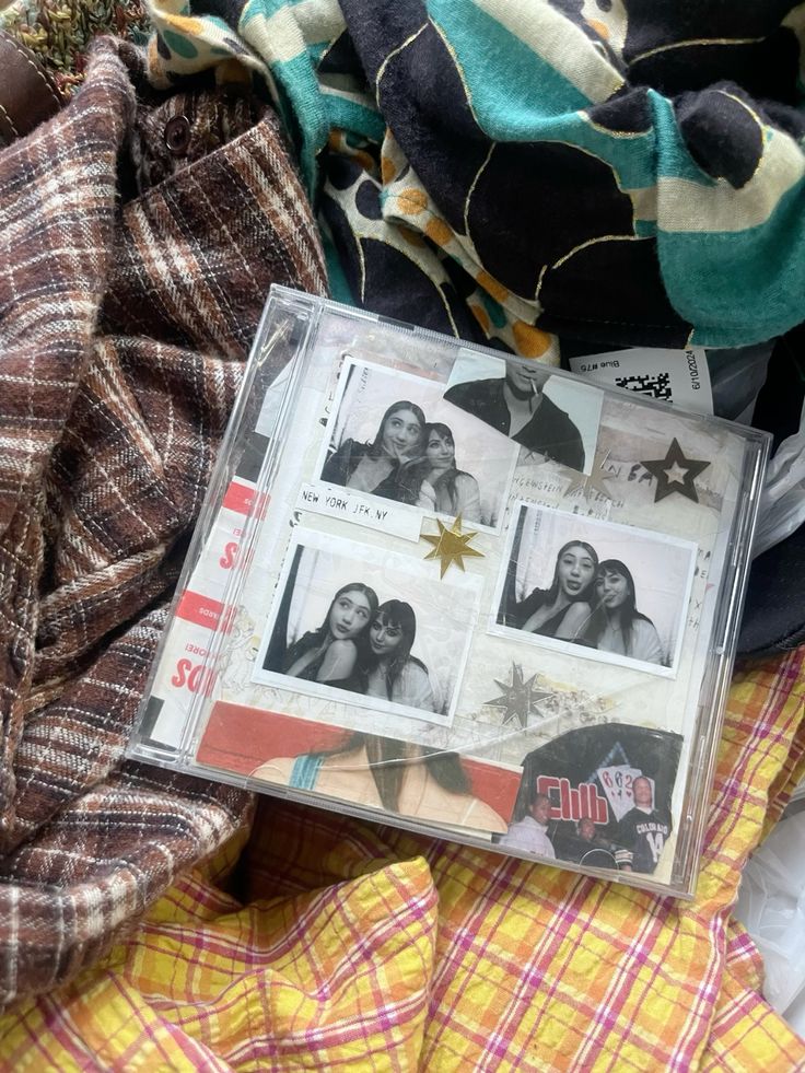 Collection of polaroids with friends on a photo album, surrounded by colorful, patterned fabric. Nostalgic and cozy vibes.