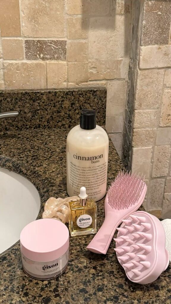 hair wash day✨ - Handy Home Bathroom vanity with hair care essentials: shampoo, hair oil, cream, brushes, and clips on a granite countertop.