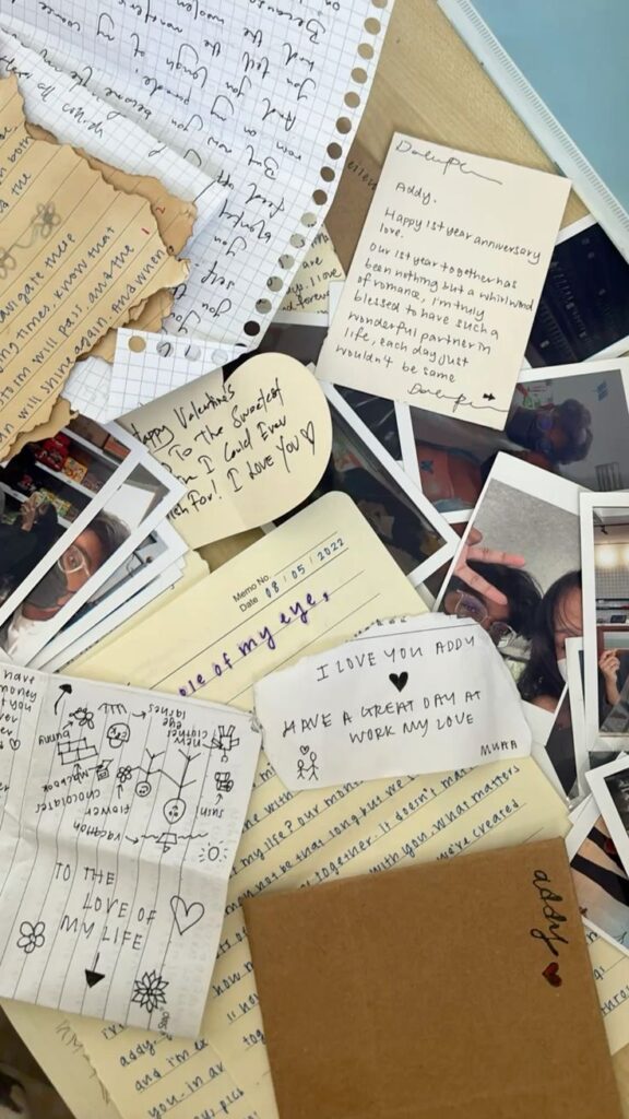 Collection of handwritten love notes and polaroid photos, expressing affection and memories, scattered on a desk.
