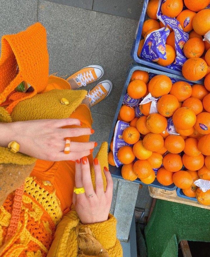 rsgbaetg - Handy Home Colorful fashion ensemble with orange outfit and manicure next to a fruit stand filled with bright oranges. Vibrant street style.