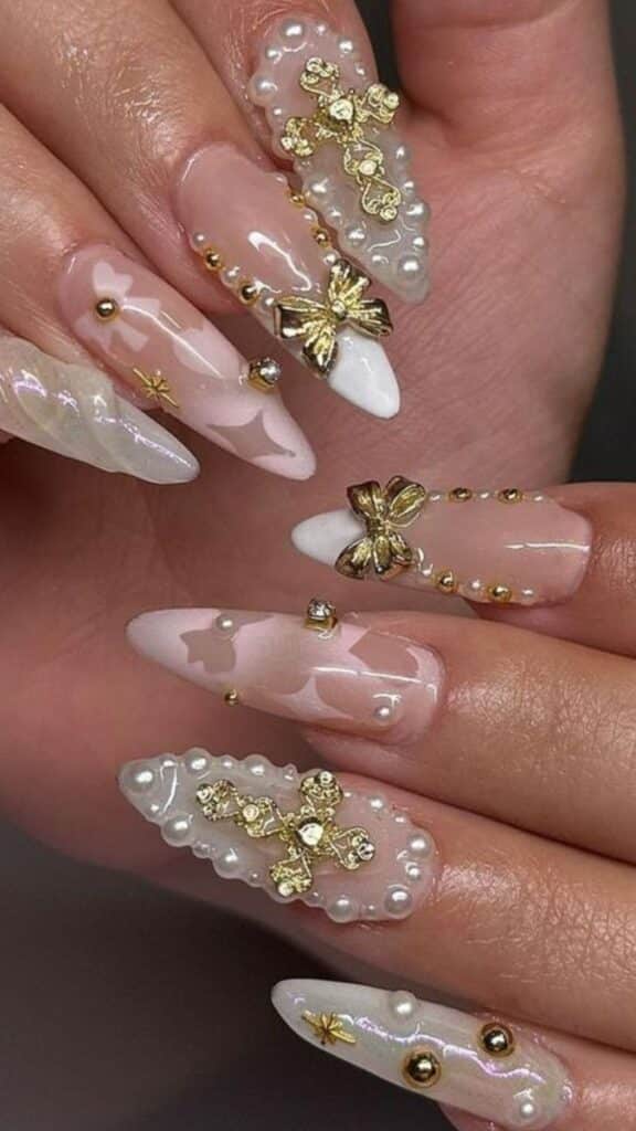 0c9482f4-8e85-4ab0-b0d2-63b097268add - Handy Home Elegant stiletto nails with gold and pearl 3D designs, featuring bows and floral accents, perfect for a glamorous look.