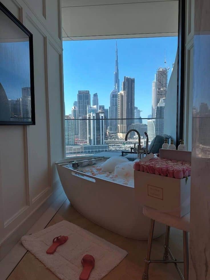 11f36e30-4f61-47e5-ab6d-fbc372735919 - Handy Home Luxurious bathroom with a stunning city skyline view, featuring a freestanding tub and elegant decor. Perfect for relaxation and indulgence.