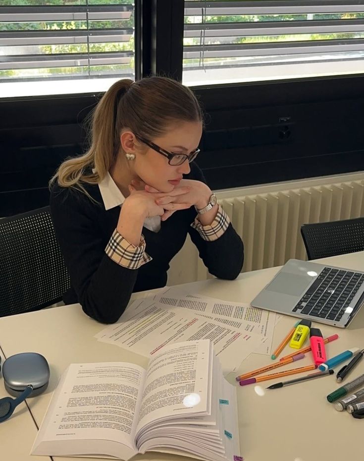 1443be7a-2e49-4b50-93d0-dc8a58dffe07 - Handy Home Young woman studying at desk with laptop, notes, and colorful pens, focused on reading documents.