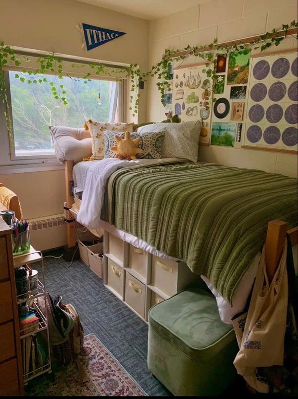 2023 Top 10 College Dorms Decor Trend for This Fall Cozy dorm room with a loft bed, green bedding, plants, and wall art, creating a warm, inviting student space. - Handy Home Cozy dorm room with a loft bed, green bedding, plants, and wall art, creating a warm, inviting student space.